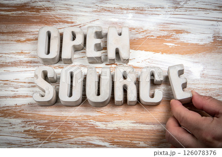 Open Source. Concrete alphabet letters on a light painted wood texture background 126078376