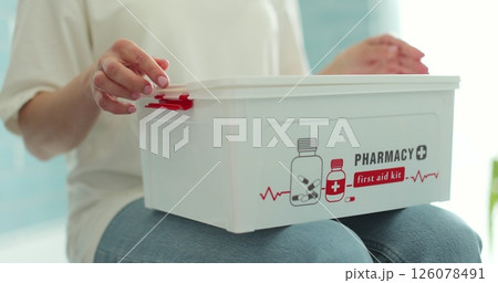 Woman takes out blister of pills from first aid kit at home. Woman takes out blister of pills from first aid kit at home. 126078491