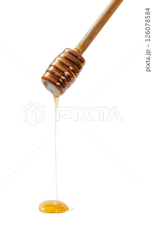 wooden honey dipper with golden honey dripping 126078584