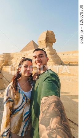Tourists taking selfie with great sphinx of giza and pyramid of khafre in background Tourists taking selfie with great sphinx of giza and pyramid of khafre in background 126079539