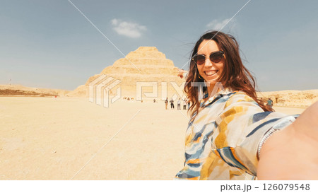 Tourist taking selfie with the step pyramid of djoser in saqqara, egypt 126079548