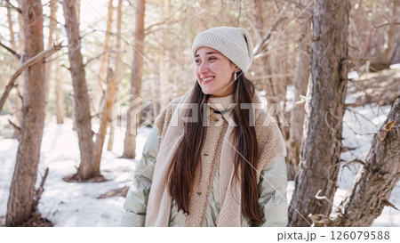 Young woman enjoying winter walk in snowy forest 126079588