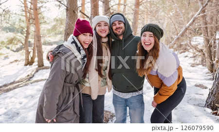 Friends laughing and hugging in snowy woods 126079590