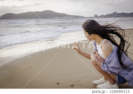 砂浜を歩く若い女性(福岡県宮地浜海水浴場) 砂浜を歩く若い女性(福岡県宮地浜海水浴場) 126080313