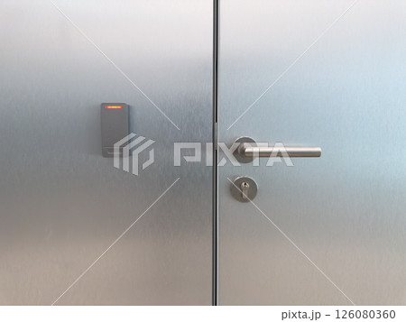 Closed metal office door with smart card reader and secure handle. Symbol of corporate access control, staff only zones, modern building security and workplace infrastructure Closed metal office door with smart card reader and secure handle. Symbol of corporate access control, staff only zones, modern building security and workplace infrastructure 126080360