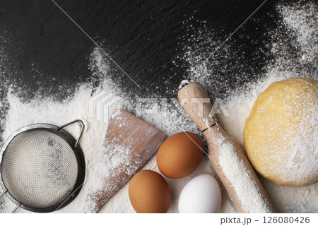Baking utensils and dough laying on flour flat lay view with copyspace Baking utensils and dough laying on flour flat lay view with copyspace 126080426