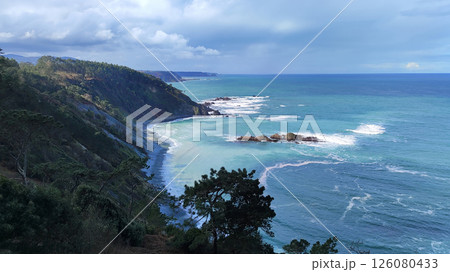 Breathtaking coastal landscape with dramatic cliffs, lush forest, and turquoise waters of the ocean. Asturias, Spain. Breathtaking coastal landscape with dramatic cliffs, lush forest, and turquoise waters of the ocean. Asturias, Spain. 126080433