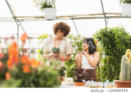 Two happy women choosing plants in a greenhouse 126080434