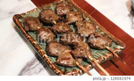 Close up of Japanese three skewers of grilled chicken gizzard on a plate in izakaya restaurant  126081974