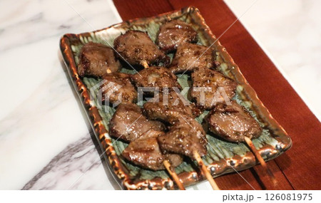 Close up of Japanese three skewers of grilled chicken gizzard on a plate in izakaya restaurant  126081975