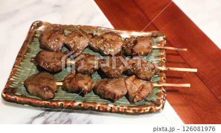 Close up of Japanese three skewers of grilled chicken gizzard on a plate in izakaya restaurant  126081976