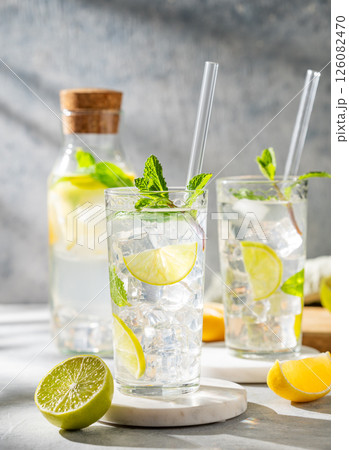 Two glasses mojito cocktail with fresh lime, mint and ice on light background Two glasses mojito cocktail with fresh lime, mint and ice on light background 126082470
