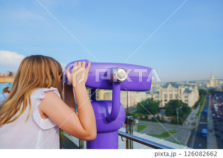 a teenage girl looks into the Binoscope from the observation deck at a height. a teenage girl looks into the Binoscope from the observation deck at a height. 126082662