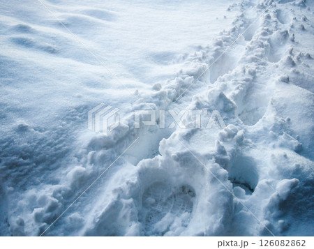 新雪に残る足跡と冬の朝の光 126082862