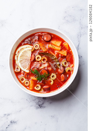 Traditional soup solyanka with smoked sausages, olives and potatoes. Traditional soup solyanka with smoked sausages, olives and potatoes. 126084182