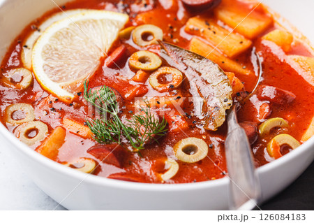 Traditional soup solyanka with smoked sausages, olives and potatoes. Traditional soup solyanka with smoked sausages, olives and potatoes. 126084183