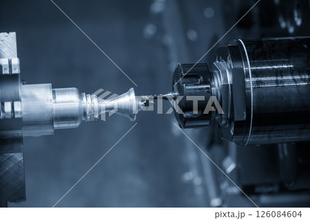 The multi tasking CNC lathe machine Swiss type milling process the metal parts in the light blue scene. The multi tasking CNC lathe machine Swiss type milling process the metal parts in the light blue scene. 126084604