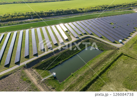 Aerial view of solar power station and green agricultural field. Sustainable development. Aerial view of solar power station and green agricultural field. Sustainable development. 126084738