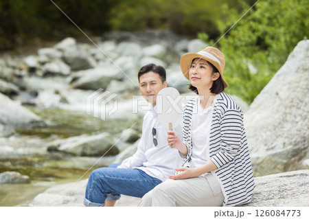 河原で水遊びを楽しむ男女 126084773