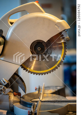 Mitre saw installed on sturdy table in woodshop. Well organized area facilitates accurate cutting 126084792