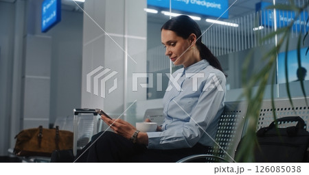 Airport Terminal: Female Entrepreneur Sitting in VIP Departure Lounge, Using Smartphone and Drinking Coffee 126085038