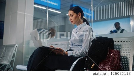 Successful Businesswoman Using Laptop Computer, Waiting for Flight in Departure Lounge Successful Businesswoman Using Laptop Computer, Waiting for Flight in Departure Lounge 126085118