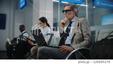 VIP Departure Lounge: Diverse Businesspeople Working with Digital Devices Waiting for Flight 126085270