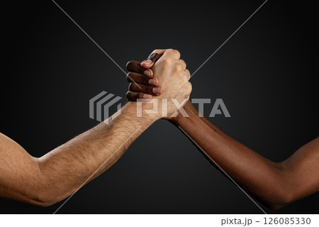 Black and white human hands shake on black background. Handshake against racism concept. 126085330
