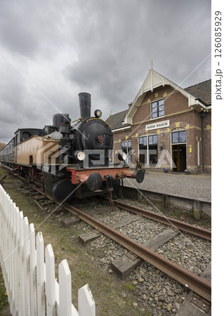 Old steam locomotive waiting at Marrum railway station in Netherlands under cloudy sky Old steam locomotive waiting at Marrum railway station in Netherlands under cloudy sky 126085929