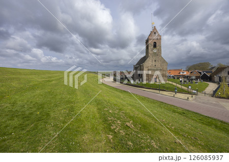 Wierum Church rising above the green dyke in Friesland, Netherlands 126085937
