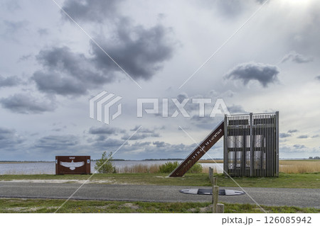 Birdwatching tower overlooking Lauwersmeer National Park under cloudy sky Birdwatching tower overlooking Lauwersmeer National Park under cloudy sky 126085942