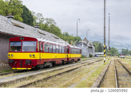 Red and yellow diesel railcar waiting at station platform Red and yellow diesel railcar waiting at station platform 126085992