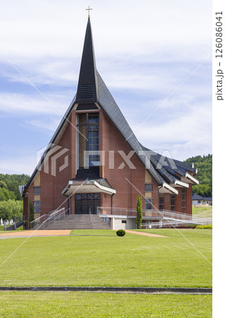 Church of Saint Roch in Jasienica Rosielna presenting its modern architecture under a cloudy sky Church of Saint Roch in Jasienica Rosielna presenting its modern architecture under a cloudy sky 126086041