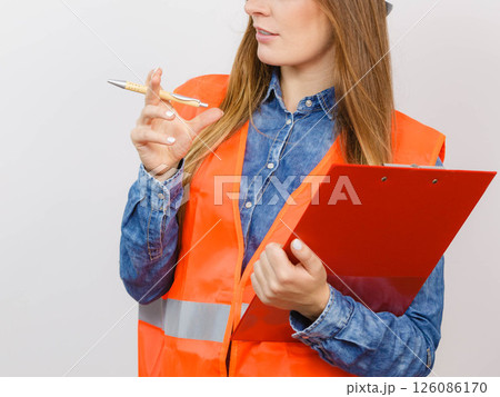 Woman engineer construction builder holds file pad. Woman engineer construction builder holds file pad. 126086170