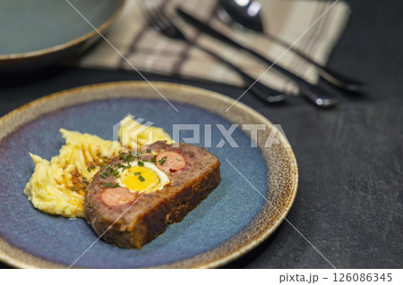 Typical Czech cuisine minced roast pork and beef with egg, sausage and mashed potatoes 126086345