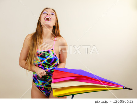 Happy woman posing in swimsuit and colorful umbrella 126086512