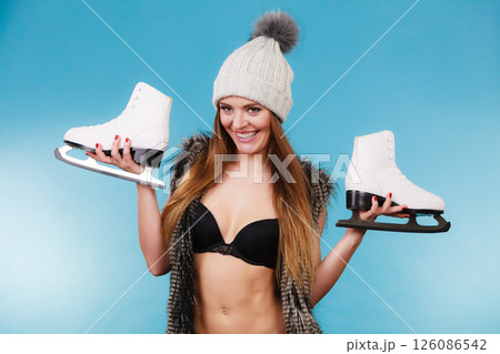 Woman wearing bikini fur vest with ice skates, winter sport 126086542
