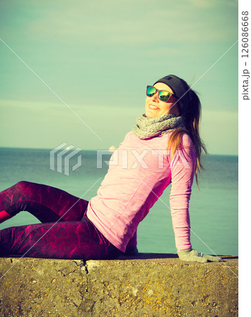Woman resting after doing sports outdoors on cold day Woman resting after doing sports outdoors on cold day 126086668