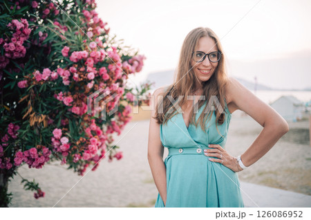 Elegant Woman Posing with Pink Flowers Outdoors Elegant Woman Posing with Pink Flowers Outdoors 126086952