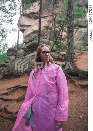 Woman in the taiga forest and rocks of the Stolby nature reserve park 126087085