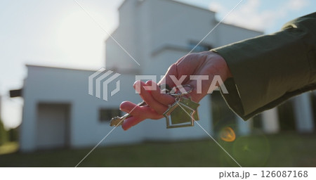 Woman hand holding key from a new house. Real estate concept for buying a new home. 126087168