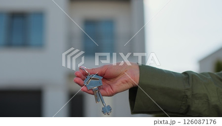 Woman hand holding key from a new house. Real estate concept for buying a new home. Woman hand holding key from a new house. Real estate concept for buying a new home. 126087176