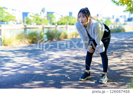 走って息切れする 息が切れる 川沿いをジョギングするかっこいい女性 走って息切れする 息が切れる 川沿いをジョギングするかっこいい女性 126087488
