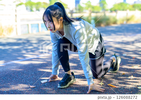 クラウチングスタート　ダイエットを始める　川沿いをジョギングするかっこいい女性　 126088272