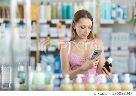 Young woman scanning qr code of syrup Young woman scanning qr code of syrup 126088347