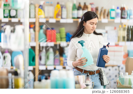 customer chooses between two sprays while standing in a supermarket customer chooses between two sprays while standing in a supermarket 126088365