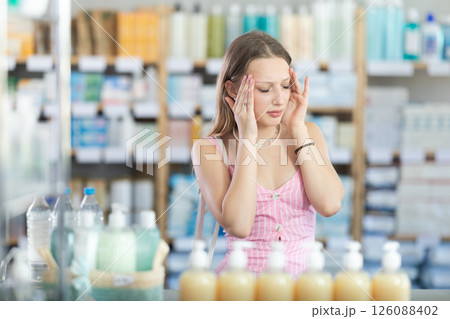 Woman with headache in pharmacy 126088402