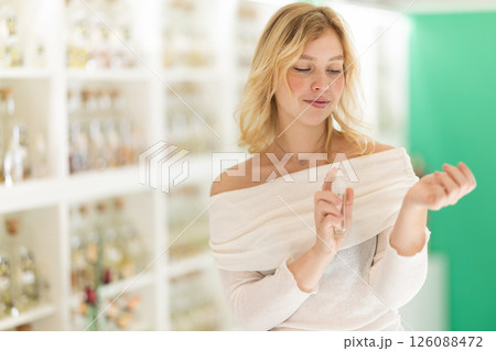 Young woman testing perfume in store 126088472