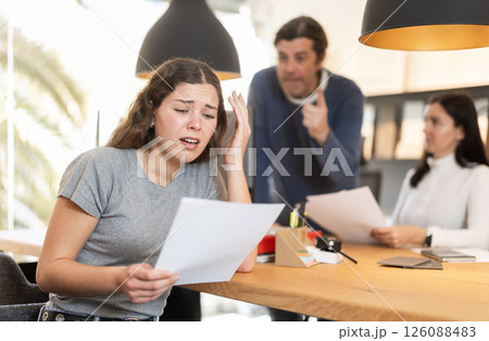 Upset girl argues with store managers, unhappy with terms of purchase agreement in furniture store Upset girl argues with store managers, unhappy with terms of purchase agreement in furniture store 126088483