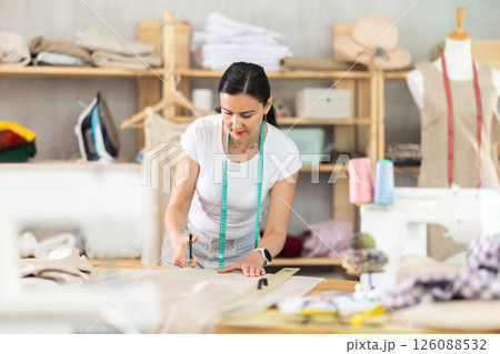 Woman seamstress cutting fabric in sewing workshop 126088532